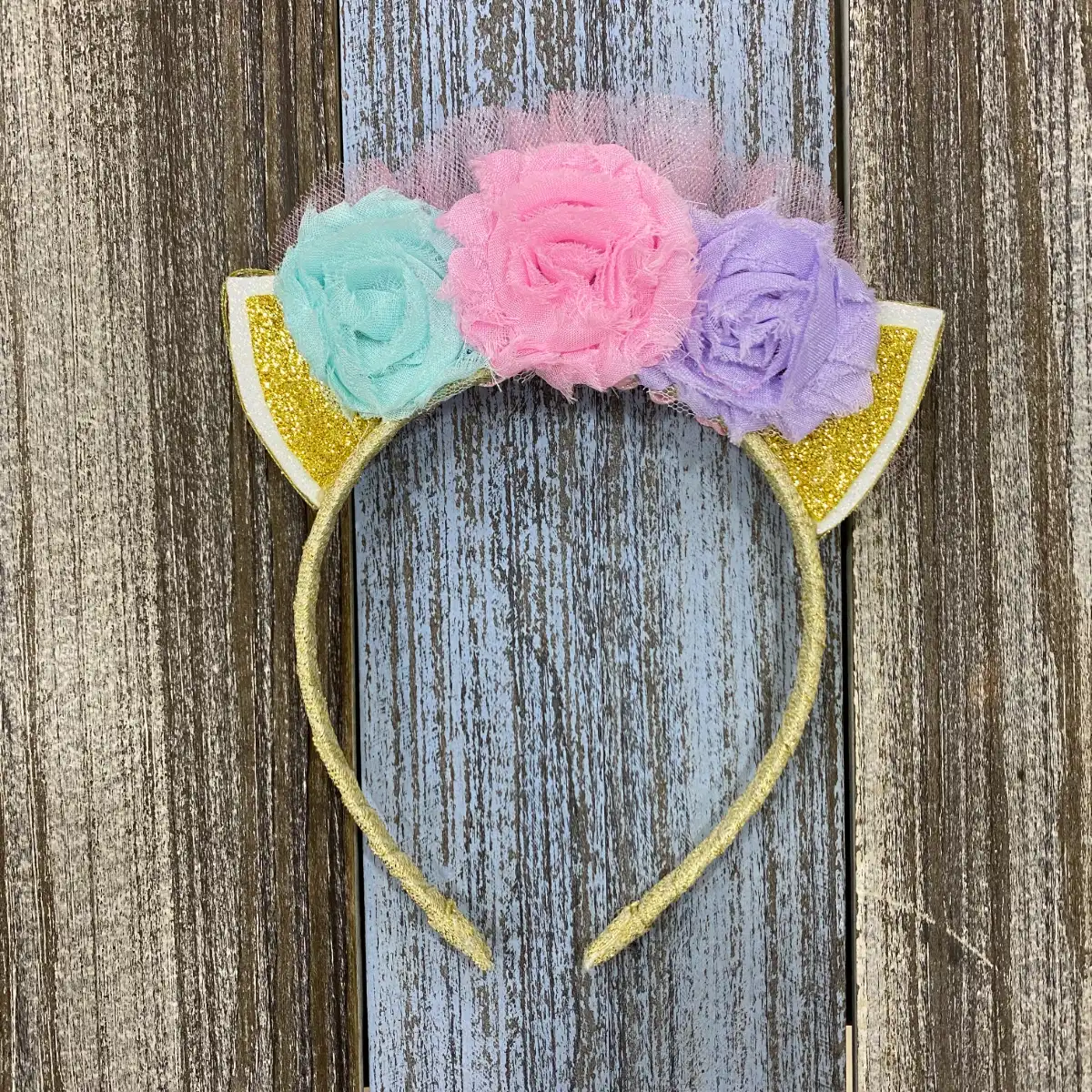 Diadema Dorada con Orejitas y Flores Menta, Rosada y Lila 1 Diadema Dorada con Orejitas y Flores Menta, Rosada y Lila